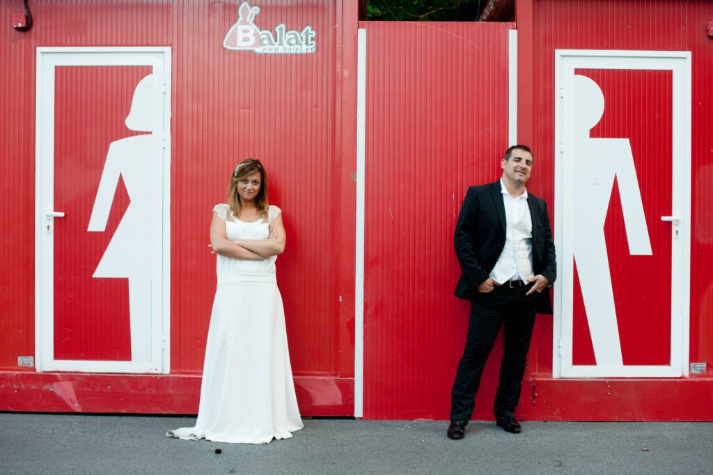 Photographe mariage Bayonne - couple de mariés devant décor rouge inspiré des fêtes de Bayonne au Pays Basque